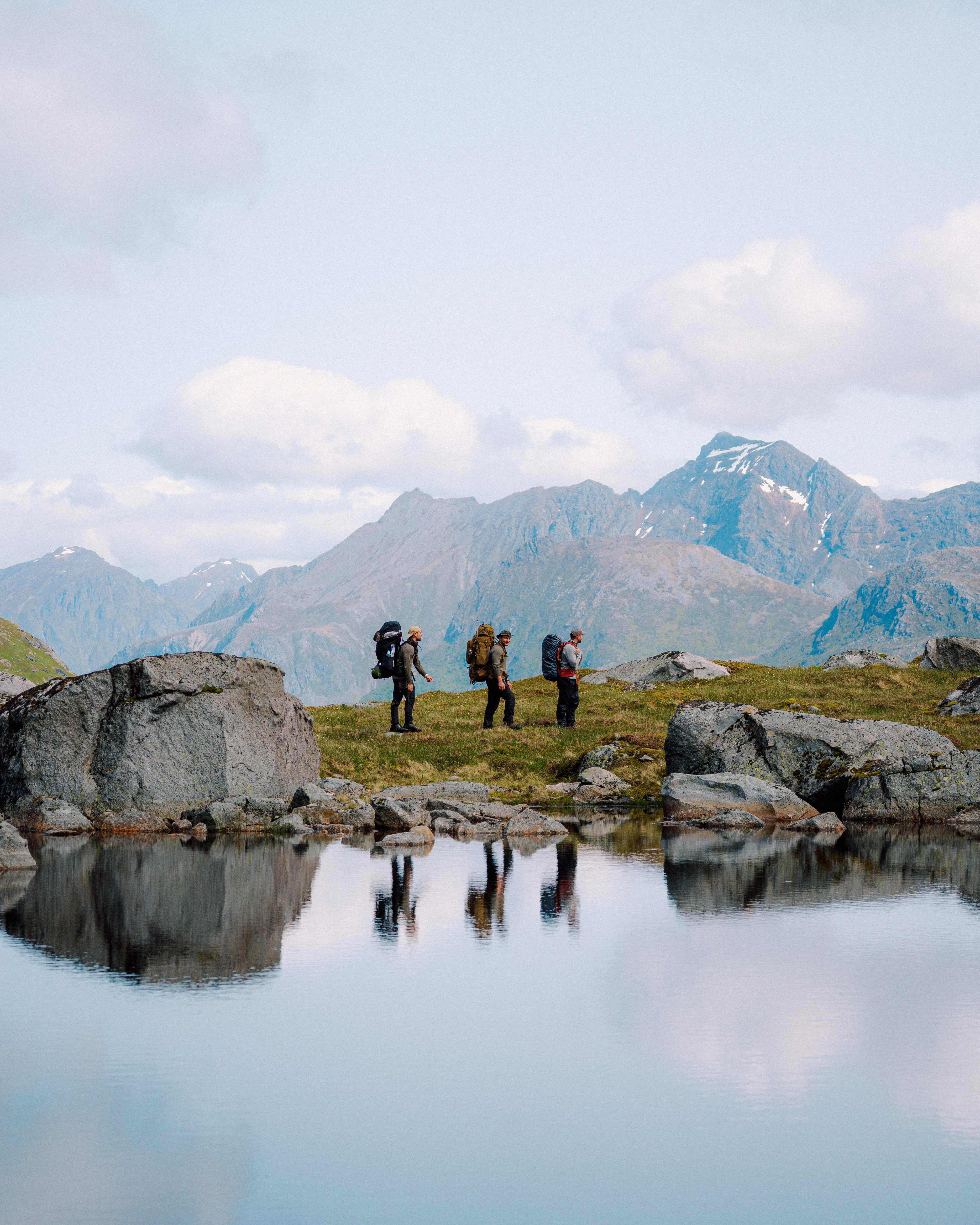 En trio på tur langs en innsjø i Lofotodden nasjonalpark