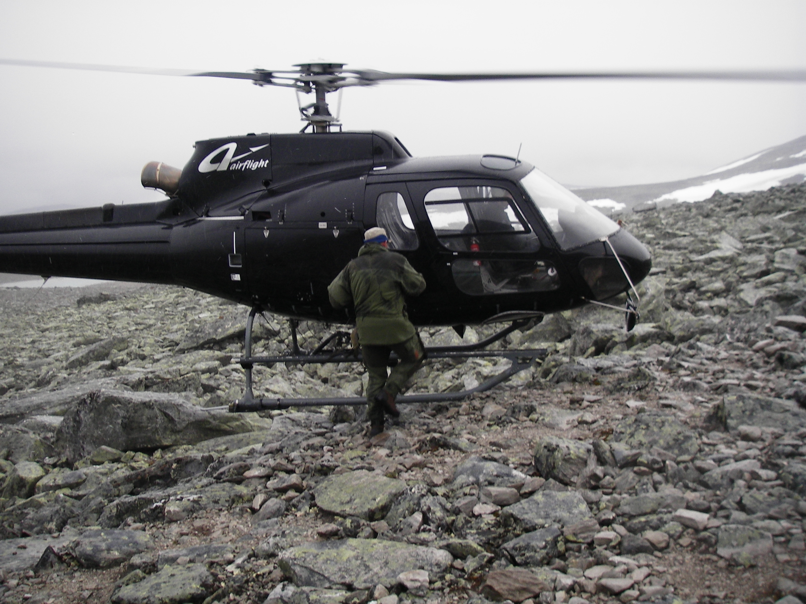 Helikopter plukker opp person på fjellet