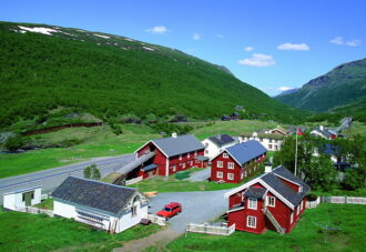 Fjellstue med mange bygninger ved vei